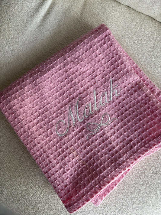 Personalised pink baby girl blanket with Malak name in script font and a white bow