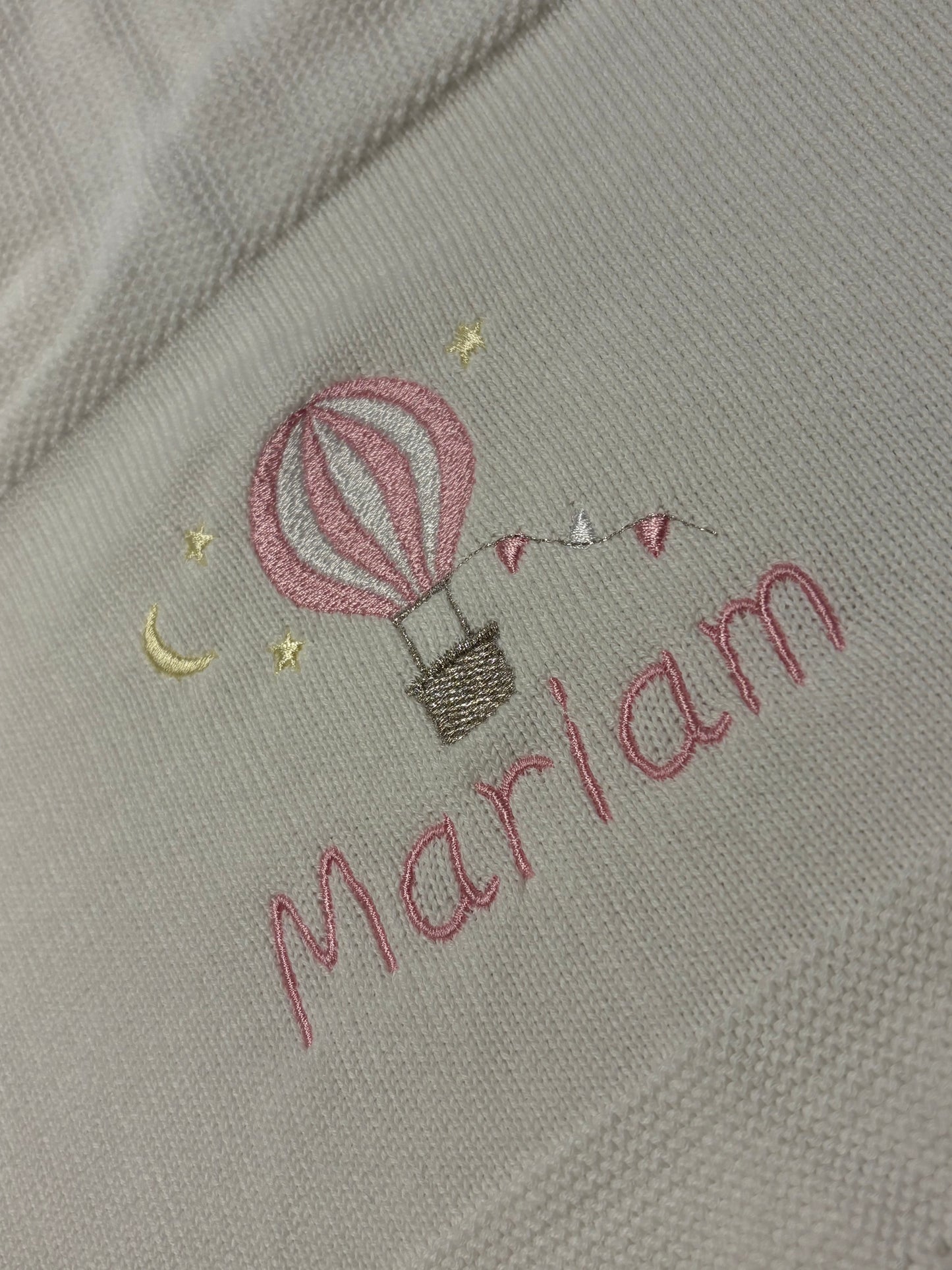 Embroidered motif design on fabric with a hot air balloon and the name 'Mariam' embroidered in pink
