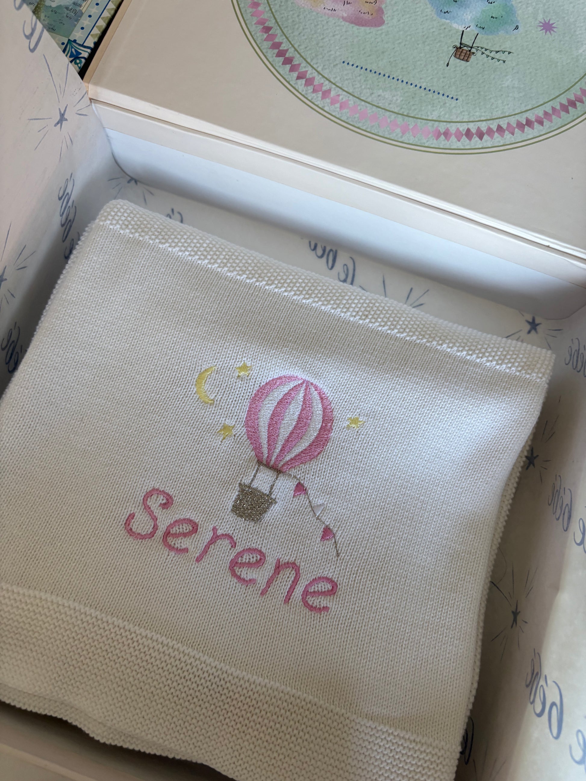 Embroidered blanket with 'Serene' and a hot air balloon design in a decorative keepsake gift box. Perfect gift for newborn
