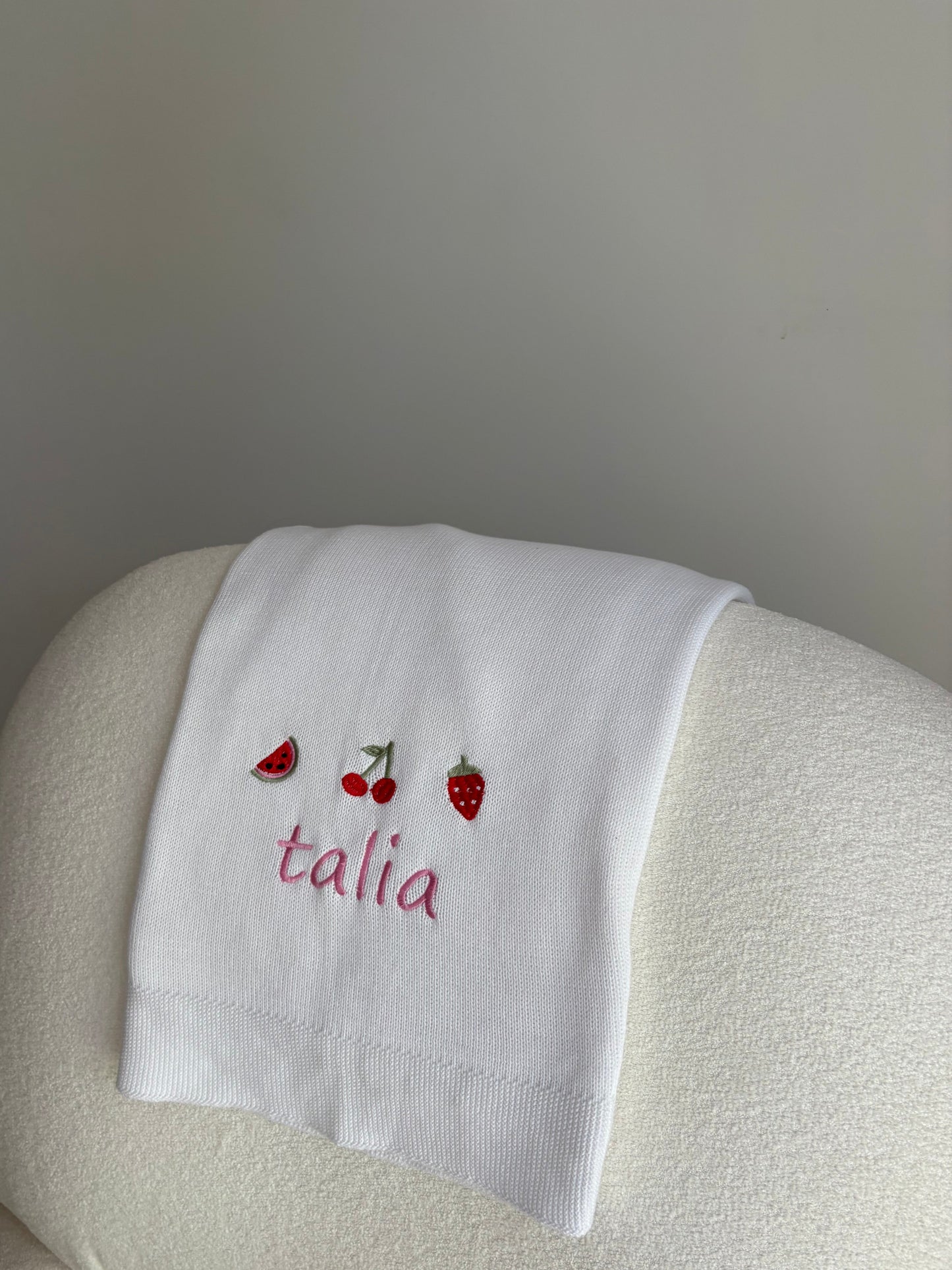 Embroidered personalised white blanket on armchair 