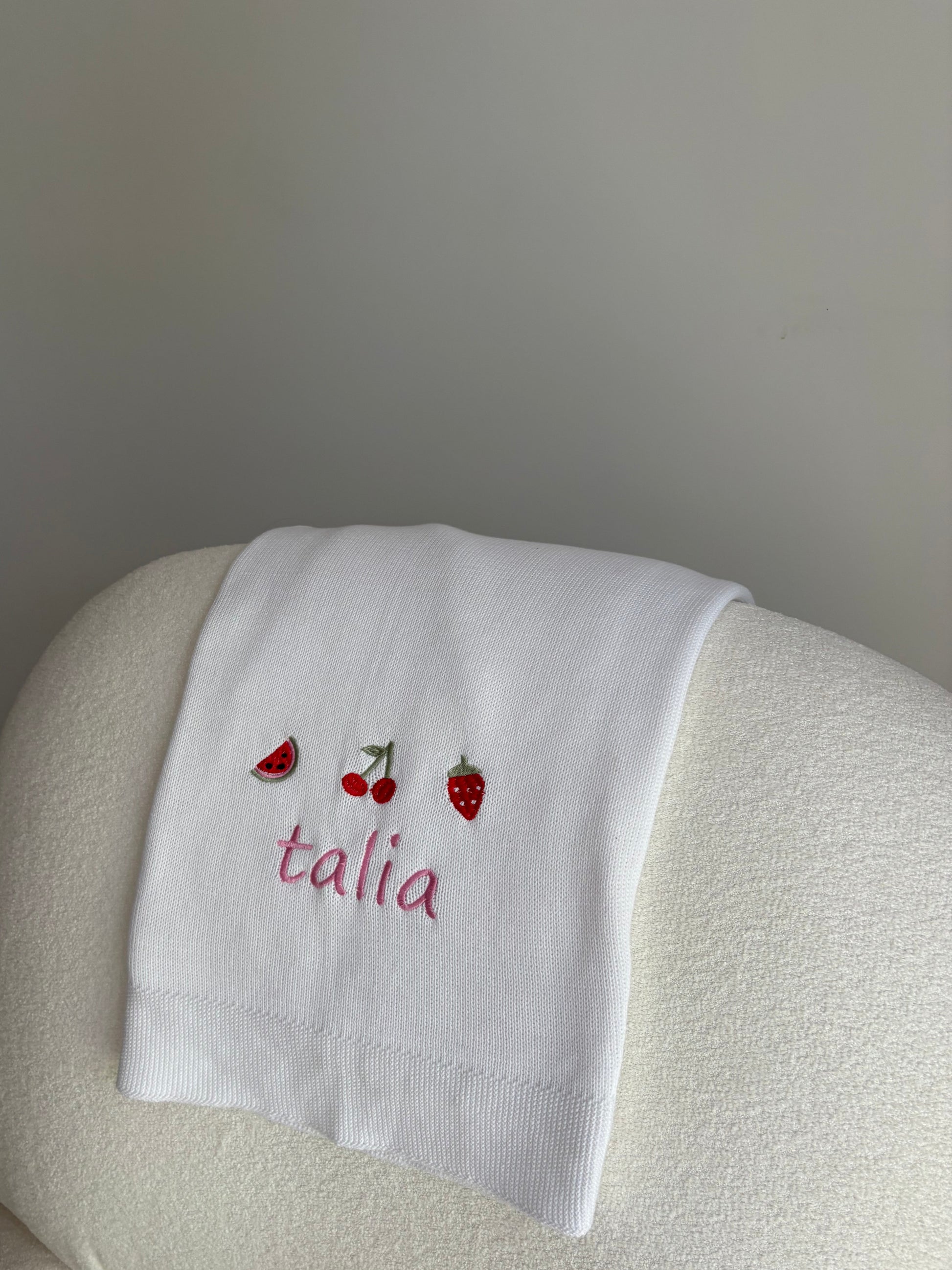 Embroidered personalised white blanket on armchair 